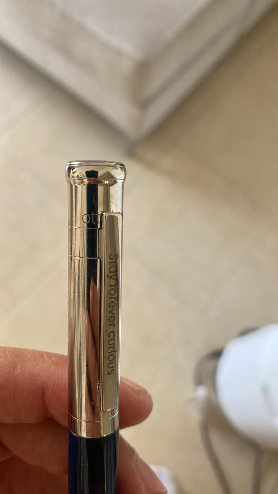 A pen engraved with the words “Stay forever curious”.